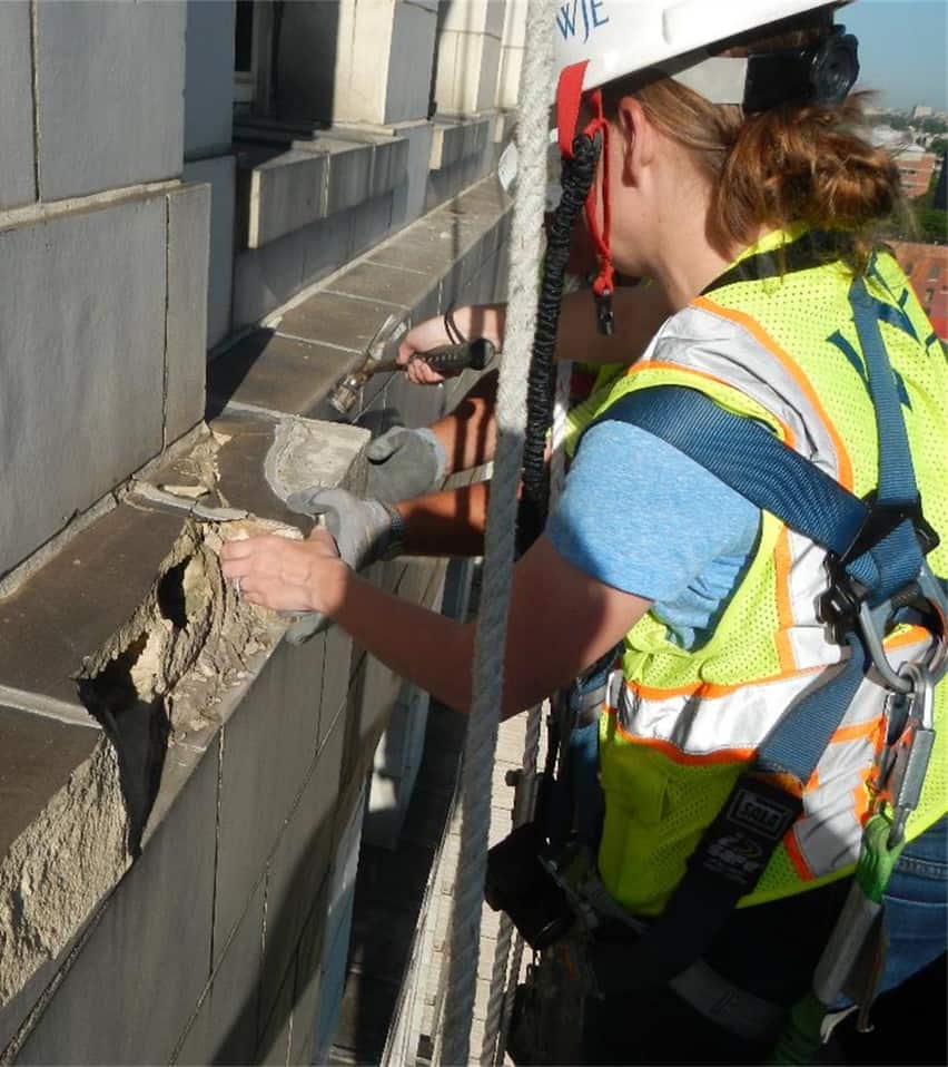 Rachel Will of WJE gets up close to inspect structural damage on the building. Photo courtesy WJE