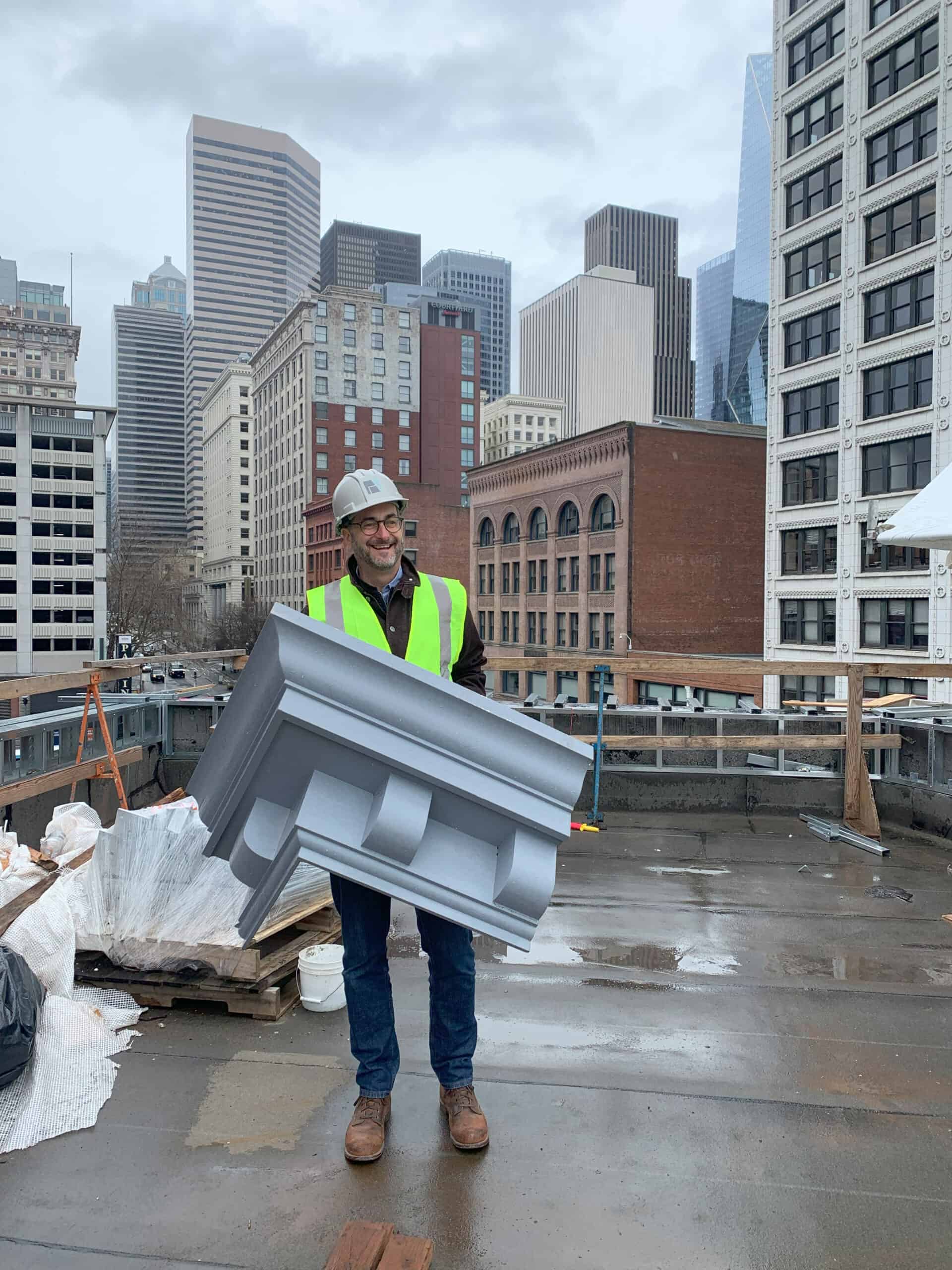 Matt Aalfs of BuildingWork, the design firm of the Metropole restoration in Seattle, holds a section of new cornice.