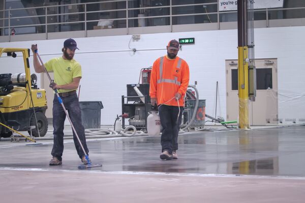 Email_Hero-CFG_LS_application_3701_Greenway_Circle_BuildSmart-14045447 Workers applying a finish to a concrete floor made with Ordinary Portland Cement (OPC) in an industrial facility.