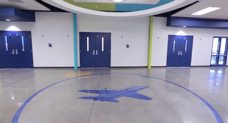Polished colored concrete floor inside a school hallway.