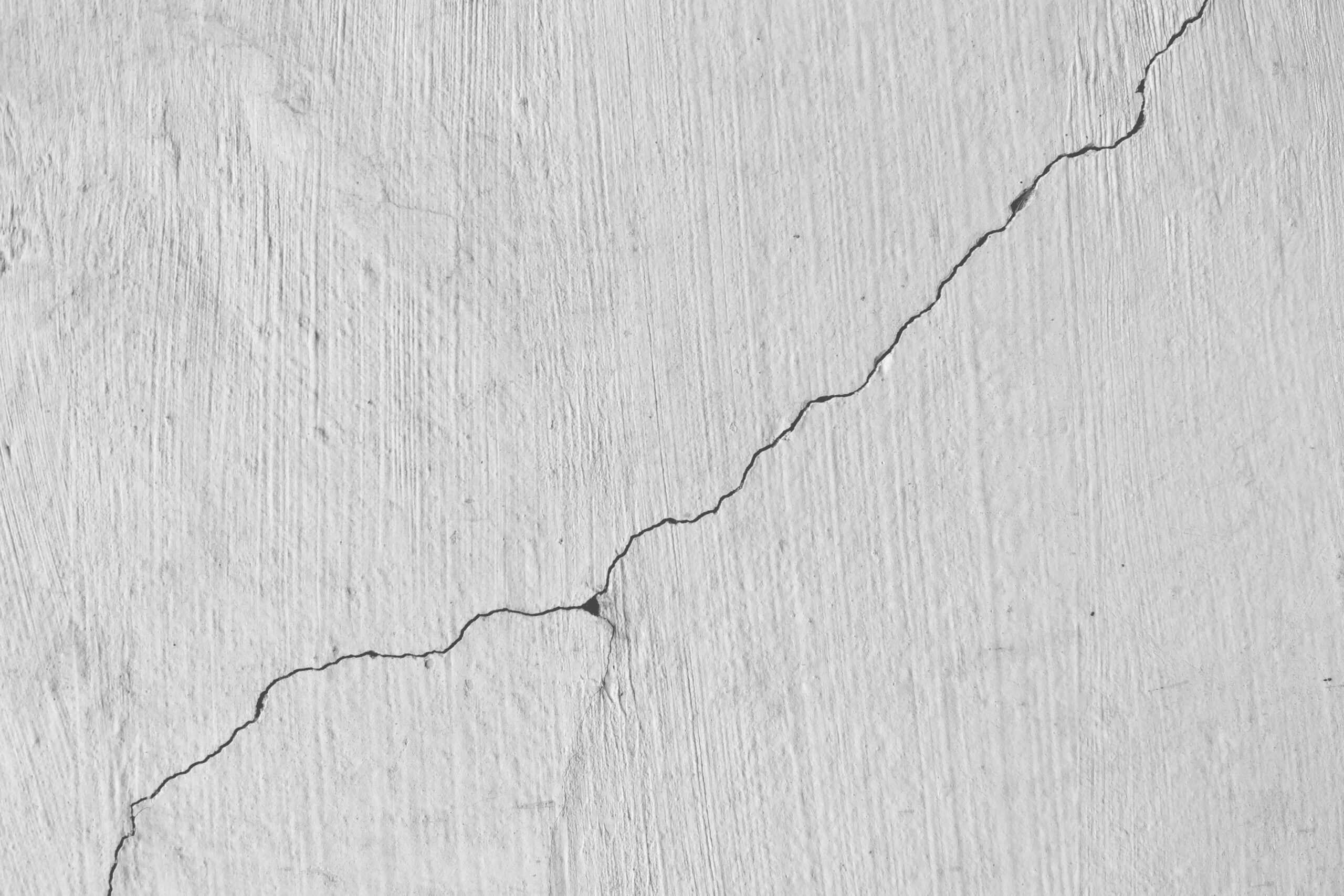 Close-up of cracked concrete with a visible diagonal fracture line.