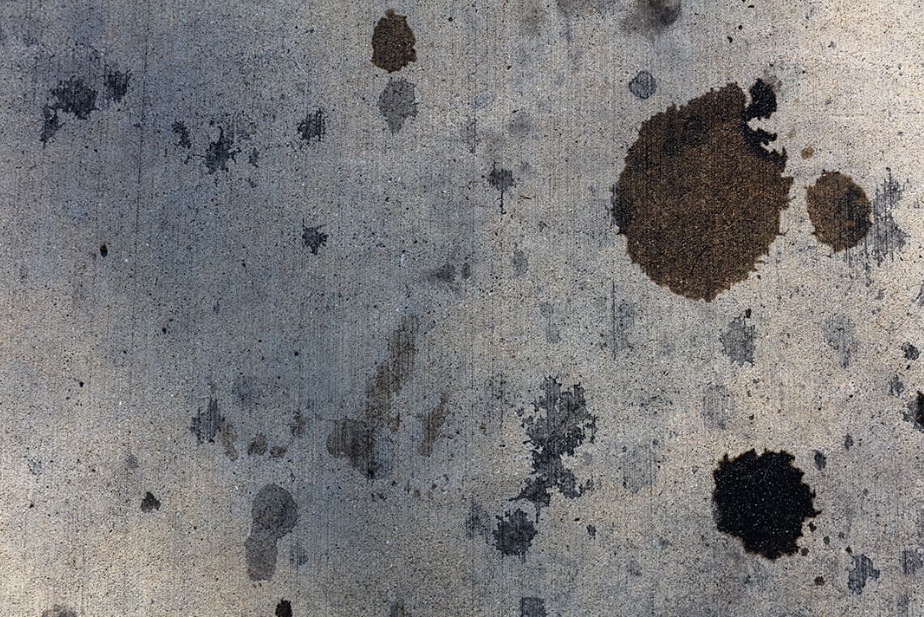 Dark mold spots and stains on a concrete surface.